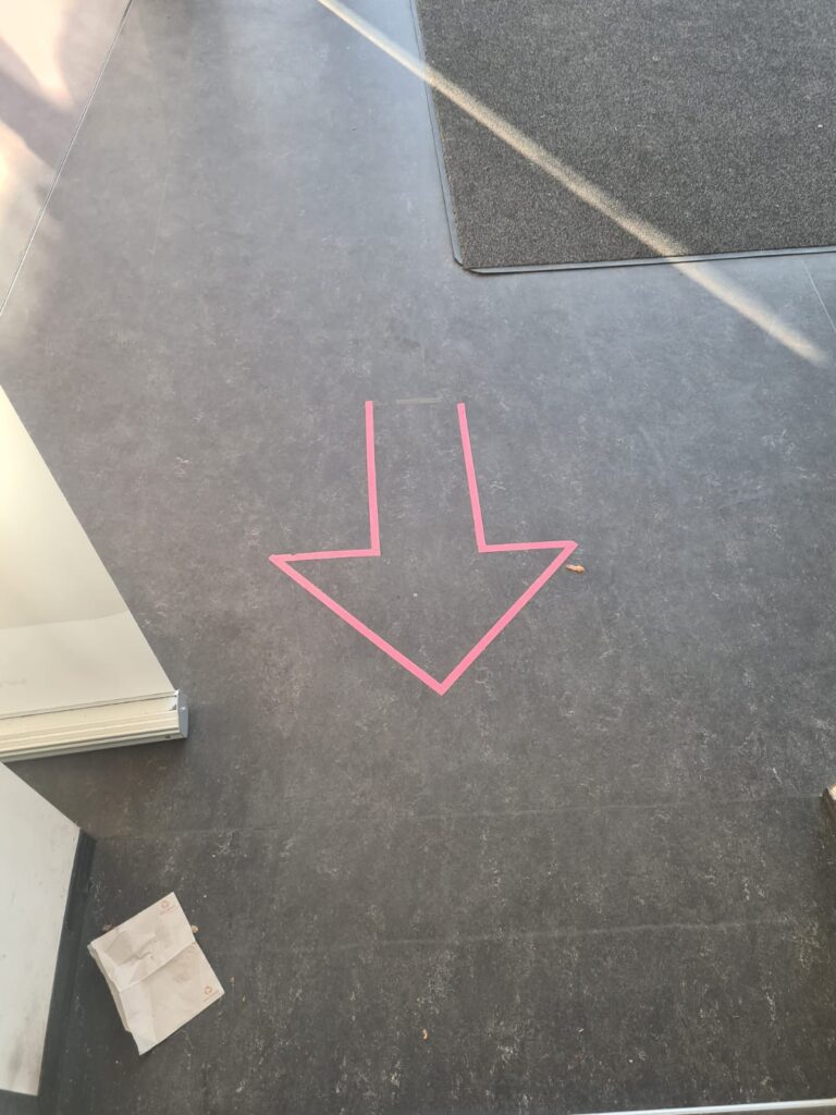Pinkfarbener Pfeil in einem Gebäude der HAW Hamburg.