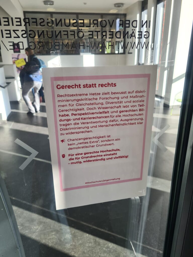 Aushang mit Pinkem Schriftsatz, der über die Demokratie-Arbeit der HAW Hamburg informiert.